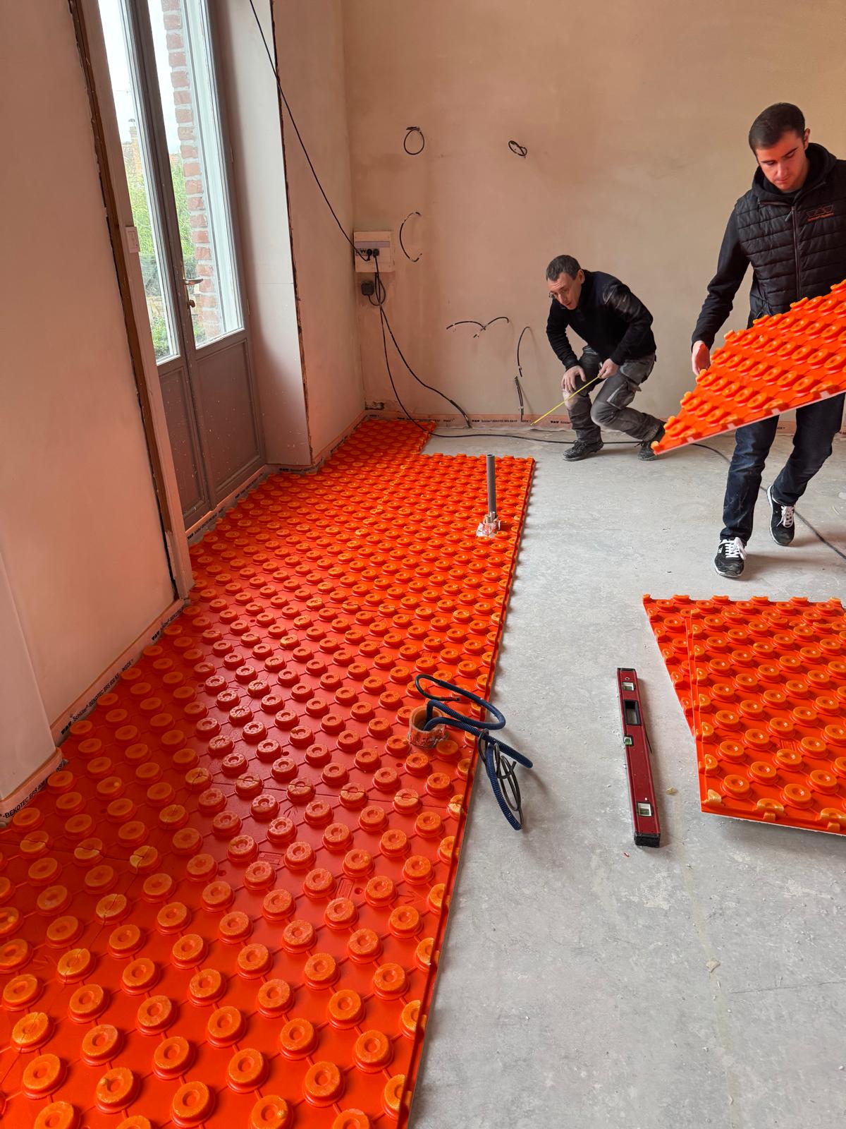 Personnes qui installent un sol chauffant